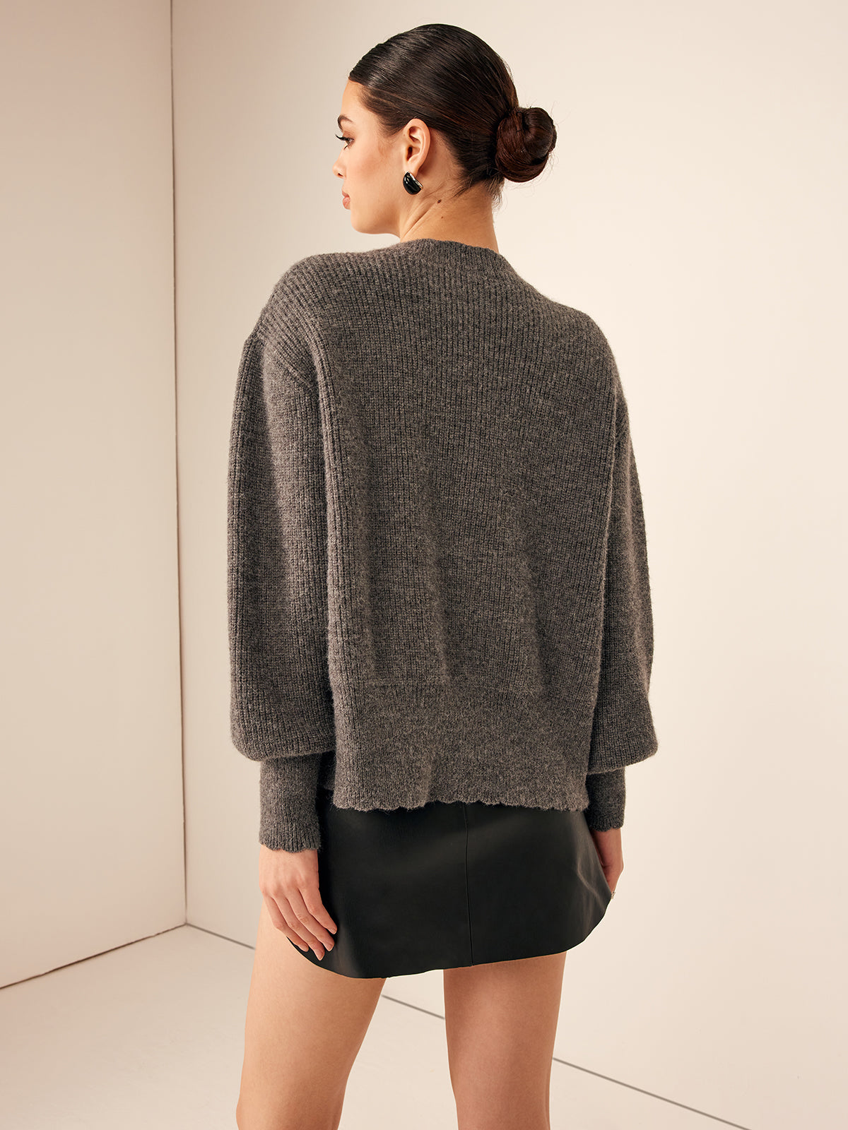 Strickjacke mit Wellenschnitt, Schleifendetail und Brustbereich