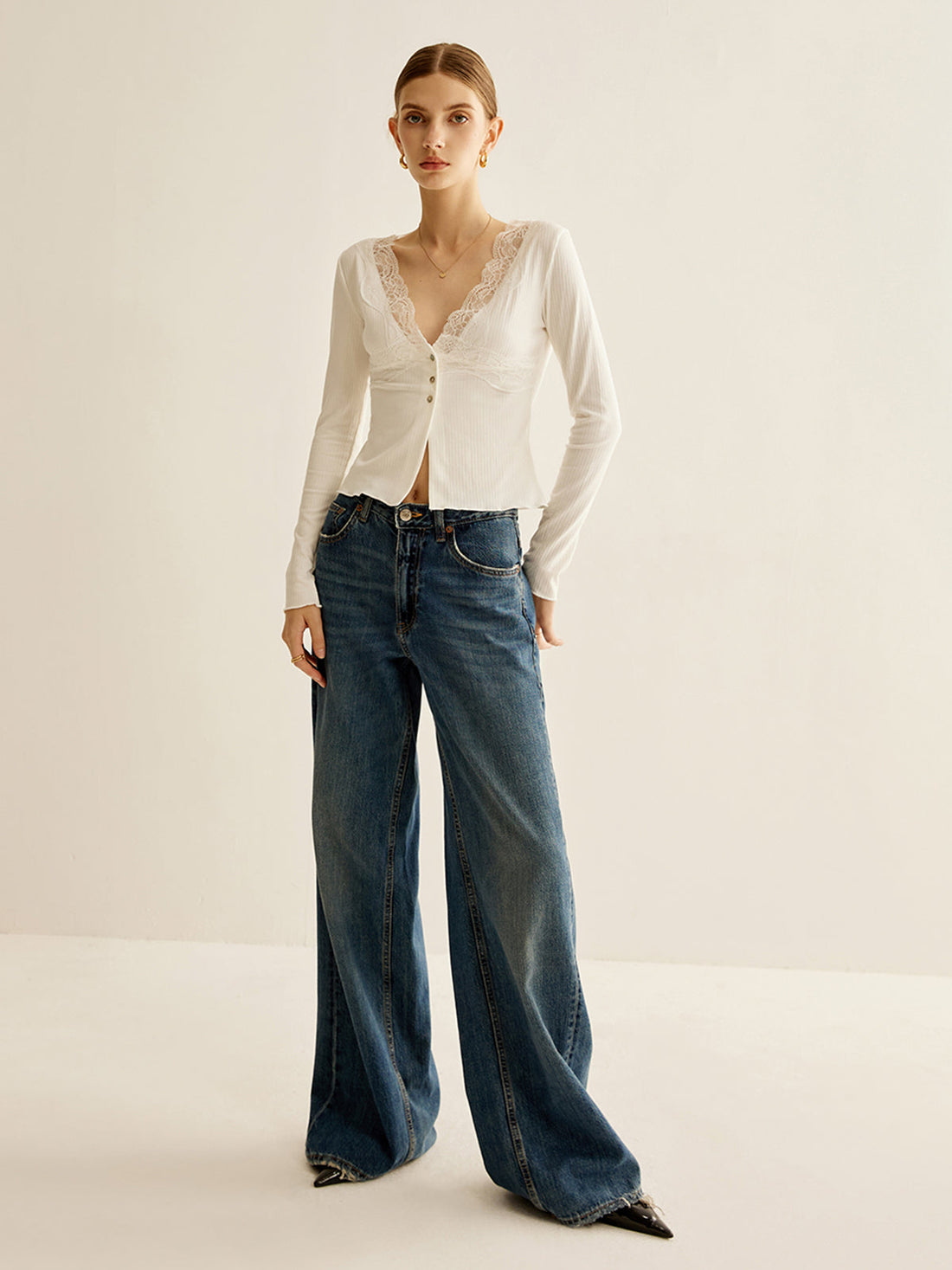 Bluse mit V-Ausschnitt und Knopfleiste, verziert mit Spitzenbesatz.