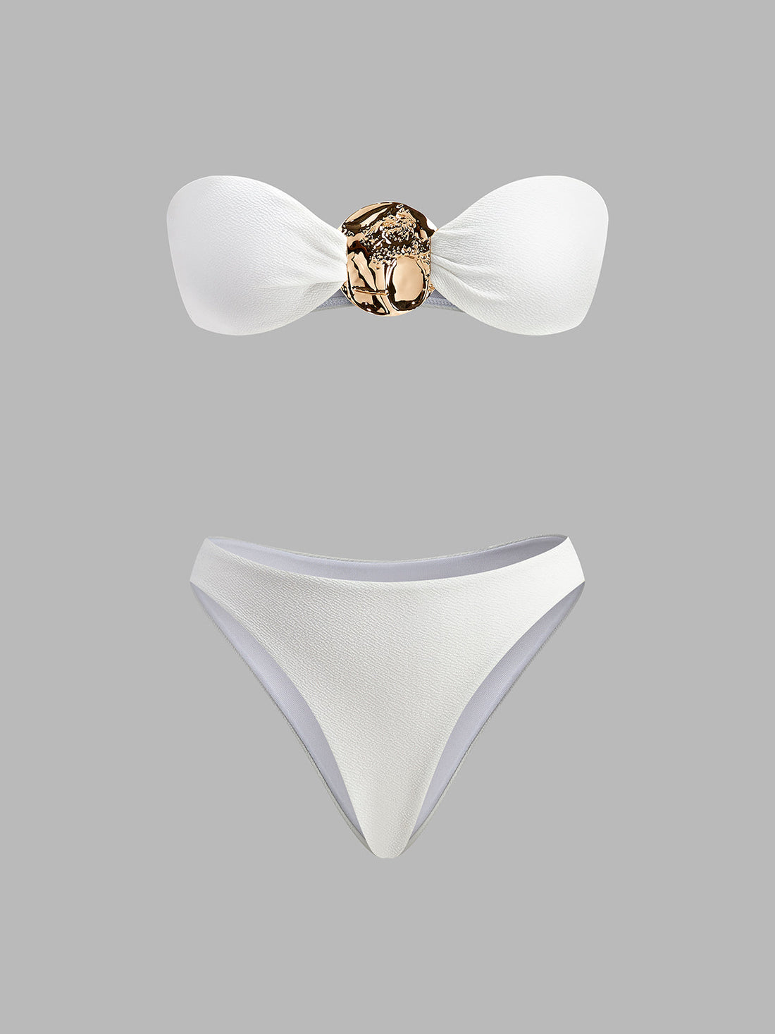 Bikini und Bettdecke mit goldenen Details.