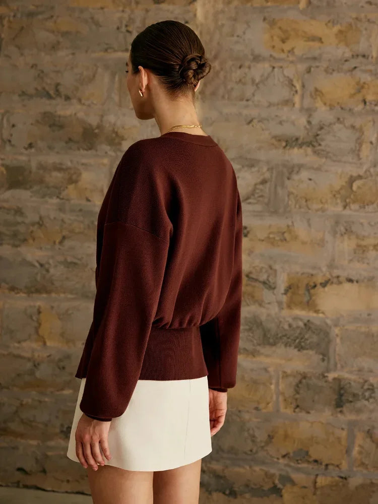 Goldene Strickjacke mit einem Knopf